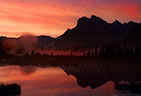 Warm, early morning light catches mist rising from one of the Vermillion Lakes.   Banff National Park, Alberta, Canada